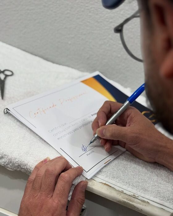 Aluno assinando o certificado do curso